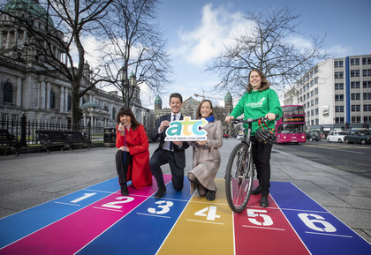 Four people stand on coloured mat to promote an event