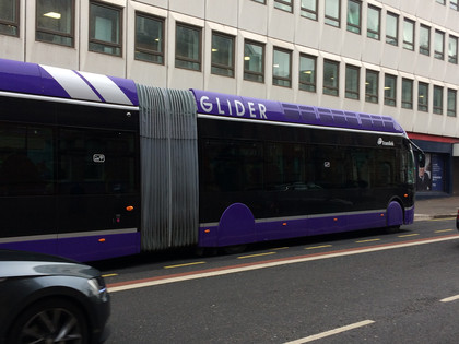 Large purple coloured bus on road